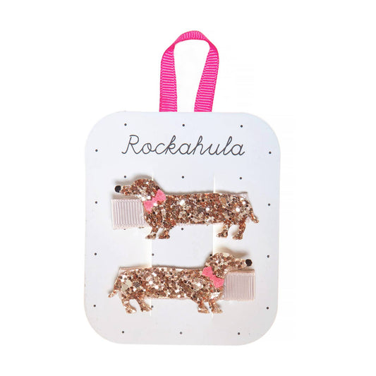 Two glittery dog-shaped hair clips on a 'Rockahula' branded card with a pink ribbon handle.